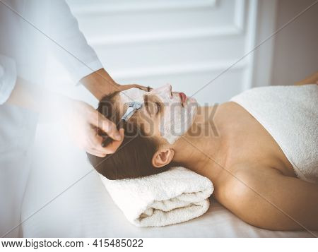 Beautiful Brunette Woman Enjoying Applying Cosmetic Mask With Closed Eyes Comfortable And Blissful. 