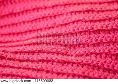 The Structure Of A Knitted Canvas Of Pink Wool Threads.