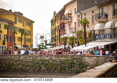 Sirmione, Italy-october 9, 2018: People Relax In The Town Of Sirmione Near The Castle Of Scaligera