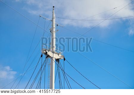 Sailing Mast Of Ship On Blue Cloudy Sky Background, Copy Space. Sailing Vessel Main Topgallant Mast.