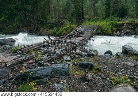 Atmospheric Rainy Landscape With Forest And Bridge Over Mountain River. Dark Forest Scenery With Pow