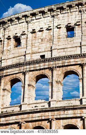 Rome, Italy. Arches Archictecture Of Colosseum (colosseo) Exterior With Blue Sky Background And Clou