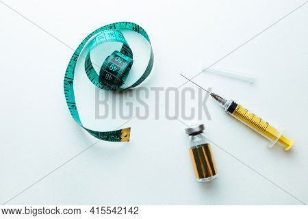 Lipolytic And Syringe On A White Background Next To A Measuring Tape For The Body. The Concept Of Lo