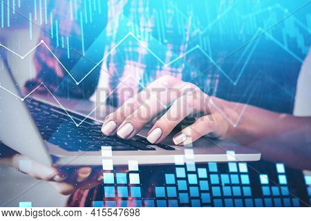 Young Woman Is Searching Information About Stock Market Behavior Holding Laptop. Financial Chart And