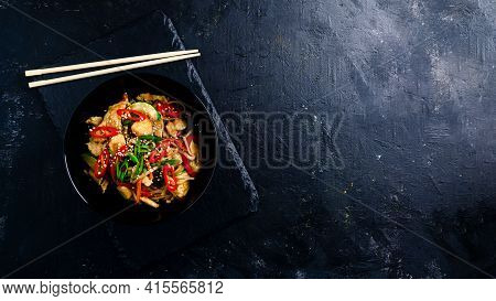 Udon Stir Fry Noodles With Chicken And Vegetables On Black Background. Hot Wok With Chicken Steaming