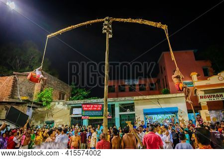 Howrah, West Bengal,india - 15th April 2019: Hindu Devotee Playing Drum While Hanging From Pole In A