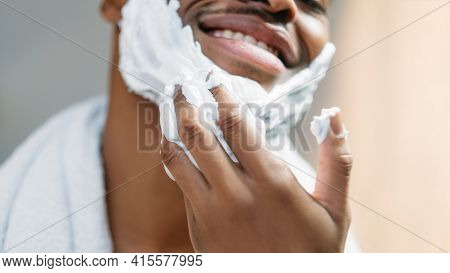 Male Facial Care. Skin Treatment. Grooming Routine. Happy Confident African Man Applying White Shavi