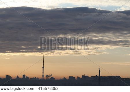 Silhouette Of The Morning City Of Kiev In The Rays Of The Rising Sun. Gray Obloka Over The City Of K