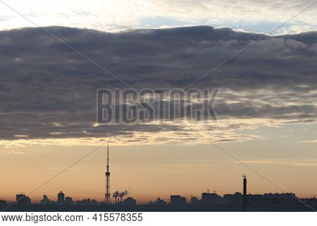 Silhouette Of The Morning City Of Kiev In The Rays Of The Rising Sun. Gray Obloka Over The City Of K