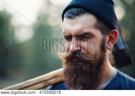Close-up Portrait Of A Brutal Bearded Man In A Dark Sleeveless T-shirt With A Large Mustache And Gra
