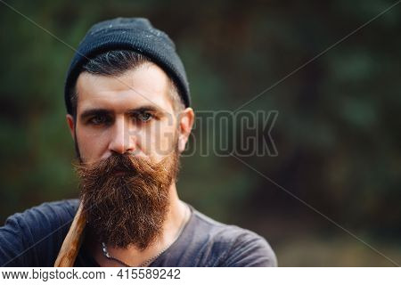 Man With Wet Beard In A Dark Sleeveless T-shirt With A Large Mustache And Gray Hair Looks Up Into Th