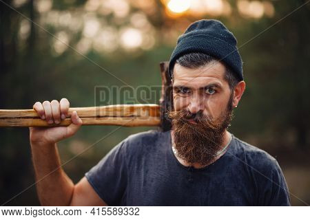 A Wet Bearded Man With A Thick Beard And A Large Mustache In A Dark Sleeveless T-shirt And A Warm Ha