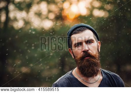 Man With Wet Beard In A Dark Sleeveless T-shirt With A Large Mustache And Gray Hair Looks Up Into Th