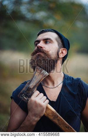 Old Man With A Large Mustache In A Dark Sleeveless T-shirt And In A Warm Hat With Gray Hair Shaves H
