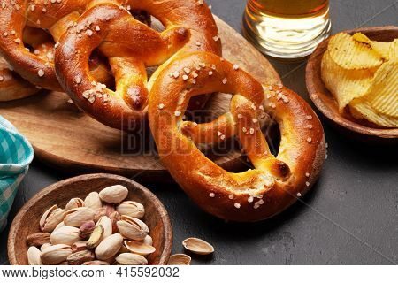 Lager beer mug, nuts, potato chips and fresh baked homemade pretzel with sea salt. Classic beer snack