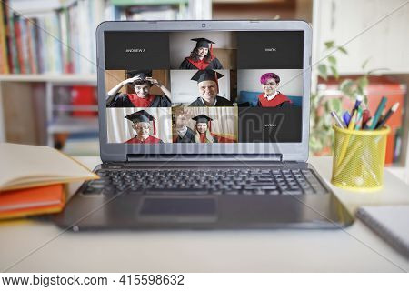 Virtual Graduation And Convocation Ceremony. Laptop Screen With Happy Students Wearing Graduation Go