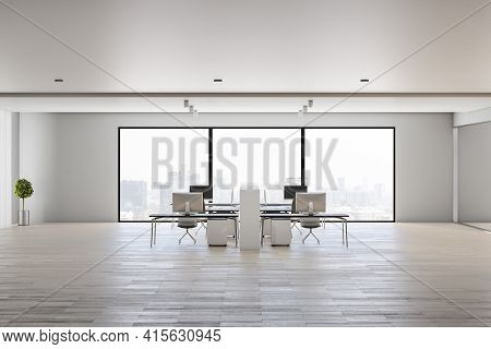 Stylish Spacious Coworking Office With Light Furniture On Wooden Floow And City Skyscrapers View Fro
