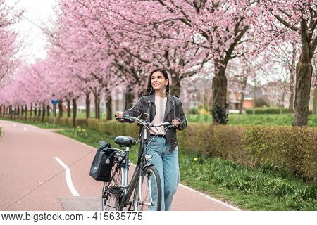 Beautiful Young Woman Of Mixed Races Minority Riding On Bicycle In Bloomy Spring In Casual Clothes W
