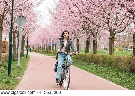 Beautiful Young Woman Of Mixed Races Minority Riding On Bicycle In Bloomy Spring In Casual Clothes W