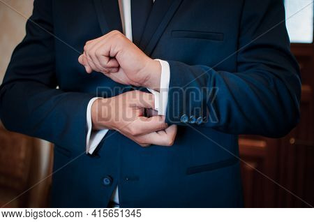A Groom Fastening A Cuff-link On The Shirt
