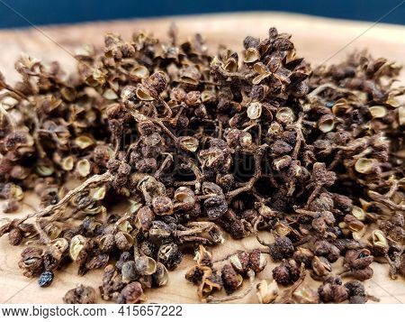 Dried Brown Andaliman Pepper On Olive Wood