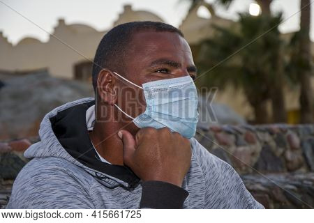 Portrait Of A Dark-skinned Man Of 40 Years In A Medical Mask On The Background Of The Urban Landscap