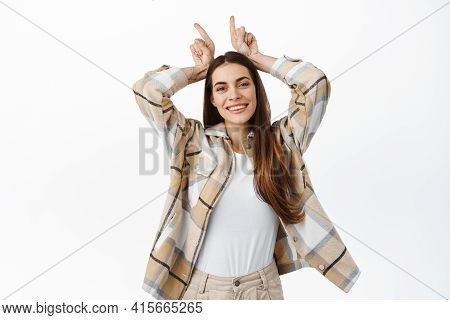 Funny And Happy Adult Woman Playing Around, Showing Bull Devil Horns Gesture And Smiling Positive, B