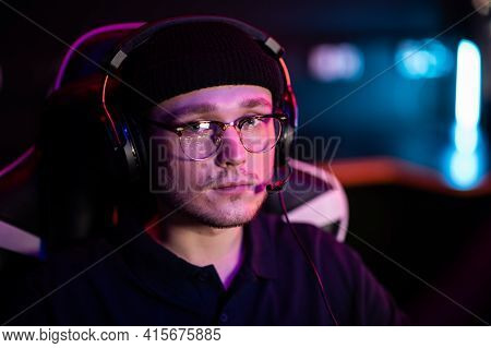 A Young Cyberathlete Wearing Glasses And A Headset At An Esports Tournament. Close-up Portrait With 