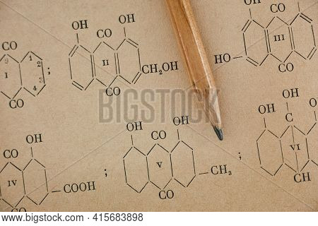 Pencil Lies On The Page Of Old Chemistry Book With Chemical Formulas. Focus On Page.
