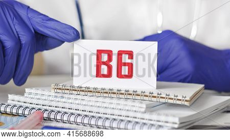 Doctor Holding A White Paper Card With Text: B6. Healthcare Conceptual For Hospital, Clinic And Medi