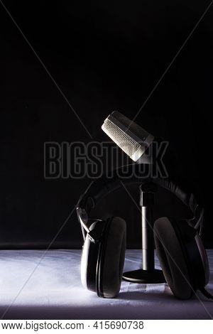 Professional Condenser Microphone And Headset On White Surface And Black Background, Low Key Portrai