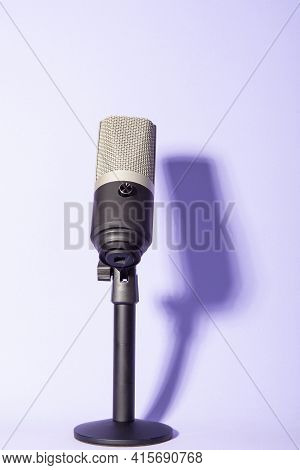 Professional Condenser Microphone With Pedestal Isolated On Violet Background Creating Shadow, Selec