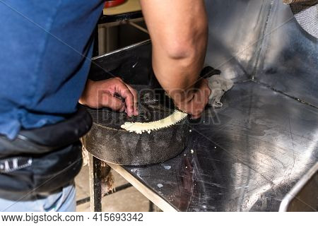 Man Putting Dough On Millstone To Be Able To Assemble Well