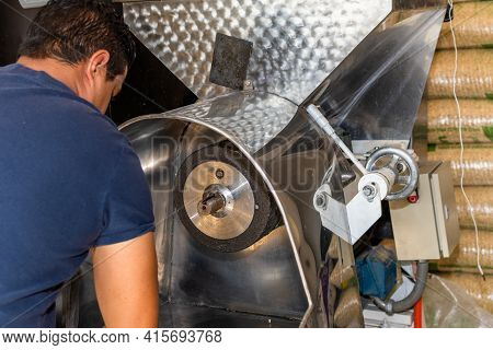 Man Turning His Back Preparing A Nixtamal Mill To Start Making Dough