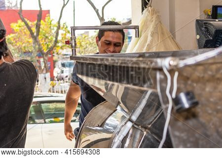 Happy And Smiling Man Taking Dough Out Of A Mill For Nixtamal
