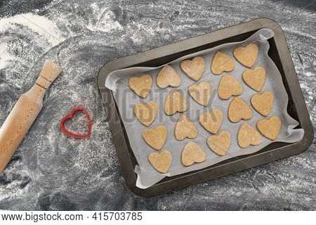 Baking Sheet With Heart-shaped Cookies And Wooden Rolling Pin. Homemade Baking