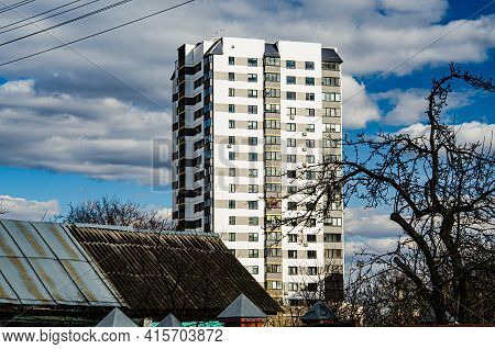 A Multi-storey Residential Building Peeking Out From Behind Old Single-storey Houses