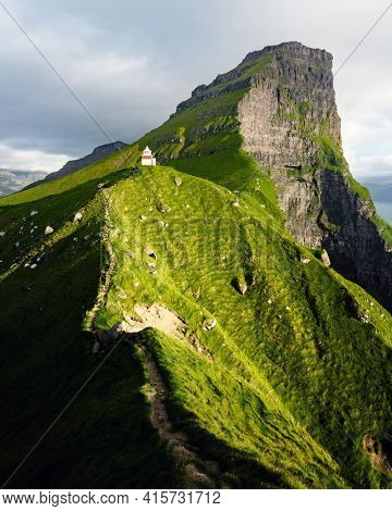 Kallur lighthouse on green hills of Kalsoy island