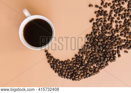 Beige Flat Lay Background With White Ceramic Cup Of Coffee, Roasted Coffee Beans Steam Shape From Ho