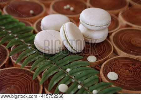 White Delicate Lowly Macaroons On A Wooden Background. The Pastel Tone Of The Cream Inside The Frenc