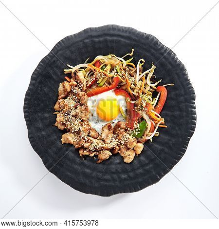 Teppan japanese cuisine - Teppanyaki Chicken with Egg and Vegetables. Sliced chicken breast on heat teppanyaki hot plate grill with sesame seed. Top view