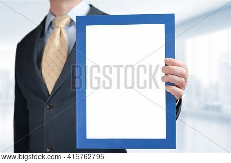 Businessman Holds Mockup Frame With Blank White Space For Certificate, Diploma, Painting. Mockup Bus