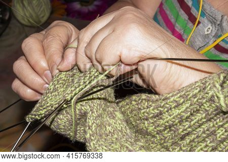 A Woman Knits Wool Socks With Knitting Needles.women\'s Hands Knit Knitting Needles Background.