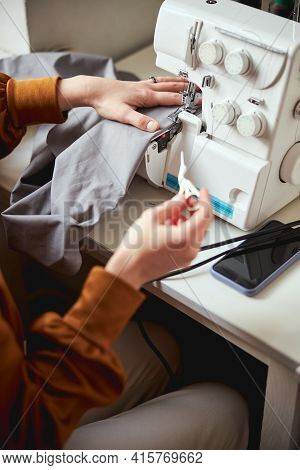 Adult Stitching Cloth With Machine While Keeping Embroidery Scissors