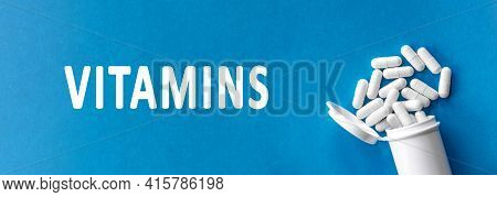 White Pills And Text Vitamins On Blue Background. Vitamin Complex. Concept, Health Care, Healthy Nut
