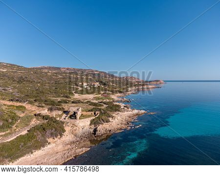 A Derelict Stone Building Standing On The Rocky Coast Of La Revellata By The Turquoise Mediterranean