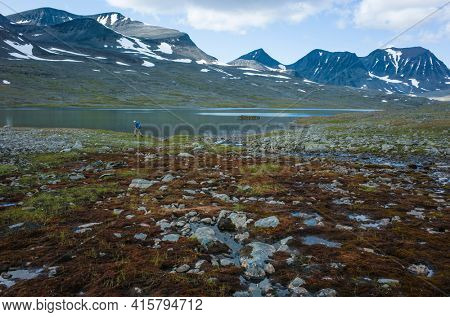 Hiking in Swedish Lapland. Man trekking alone in northern Sweden in Stuor Reaiddavaggi valley. Arctic mountain nature of Scandinavia in summer day