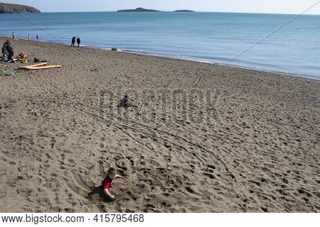 Aberdaron - Wales - April 3 2021 : Beautiful Sandy Beach With Holiday Makers Enjoying The Sun And Fi