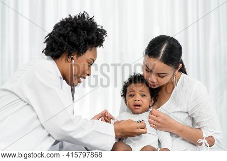 African Female Pediatrician Hold Stethoscope Exam Child Boy Patient Visit Doctor With Mother