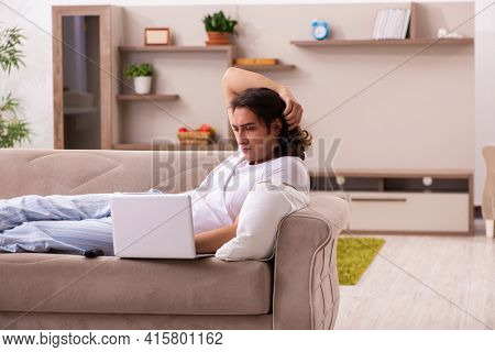 Young lazy man in oversleeping concept at home